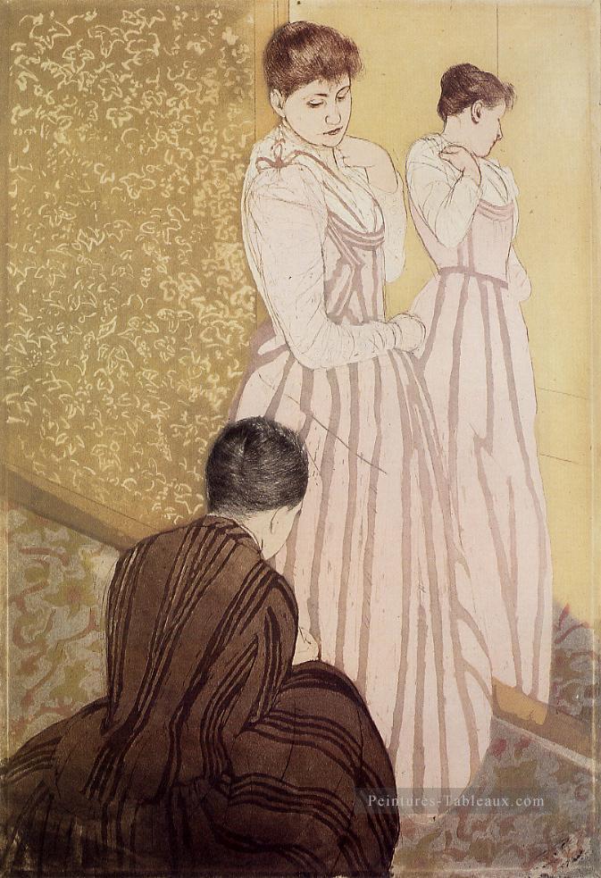Jeune femme essayant une robe mères des enfants Mary Cassatt Peintures à l'huile